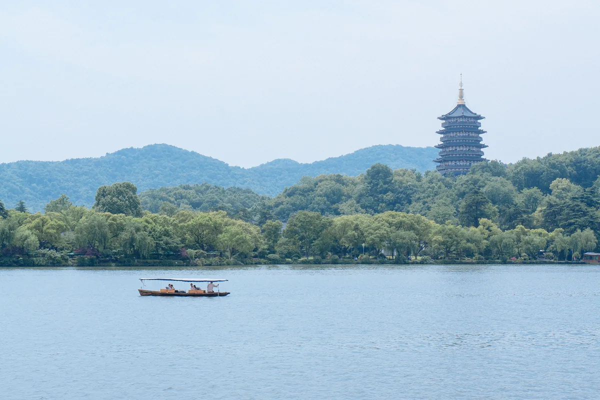 West Lake in Hangzhou with a pagoda and misty hills